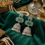 Imperial Heritage Oxidized Silver Jhumka Earrings with Deep Green Stone, Hand-Engraved Motifs, Crystal Accents & Pearl Drop Detailing.