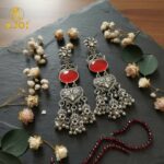 Vintage-Inspired Oxidized Silver Red Stone Jhumka Earrings with Ornate Filigree Design and Cascading Bell Danglers - Image 6
